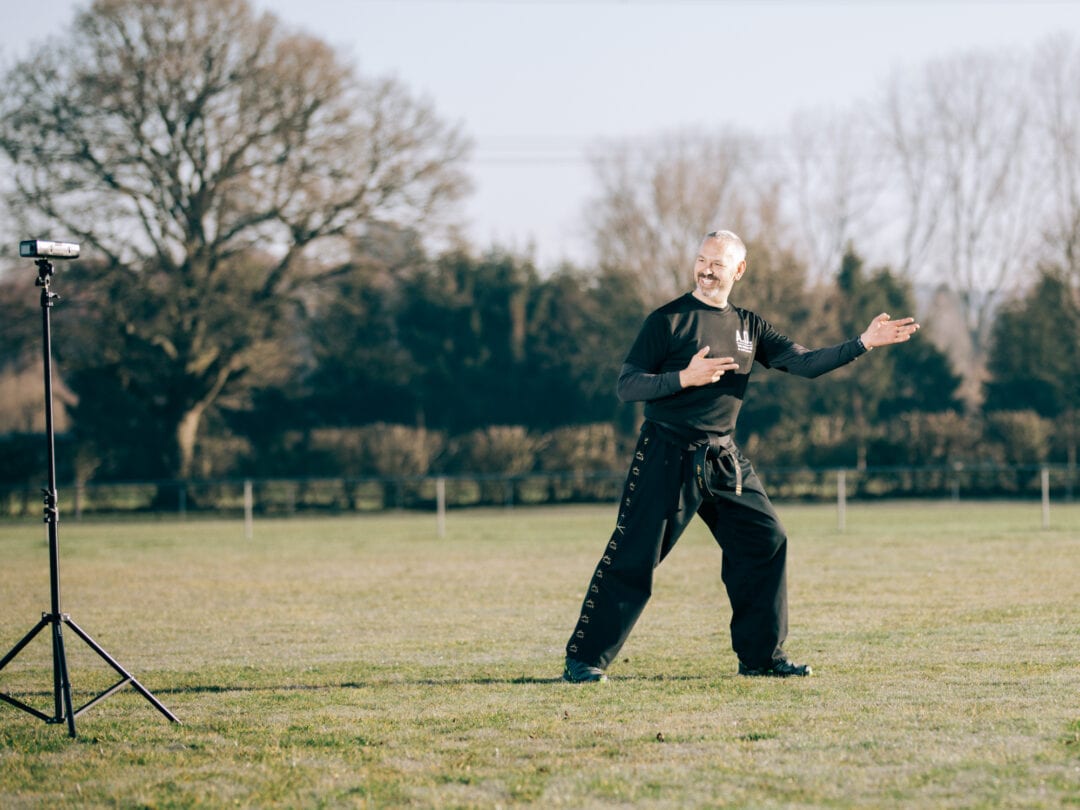 Brighton martial arts instructor demonstrating self-defence techniques outdoors in sunny park.