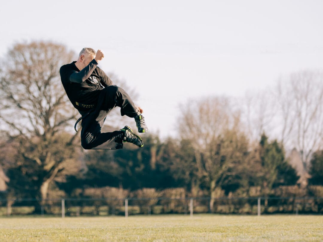 Dynamic sports photography of an athlete mid-air jump during outdoor training session, showcasing fitness and athleticism.
