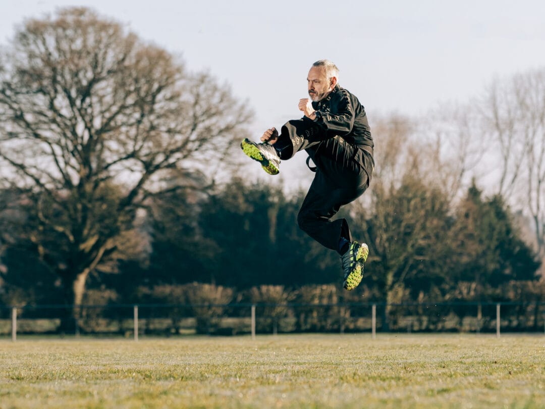 Vigorous man mid-air jump during outdoor sports session, showcasing action and energy.