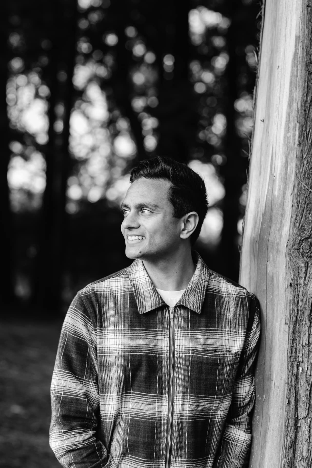 Portrait of a man smiling outdoors in black and white, professional headshot photography.