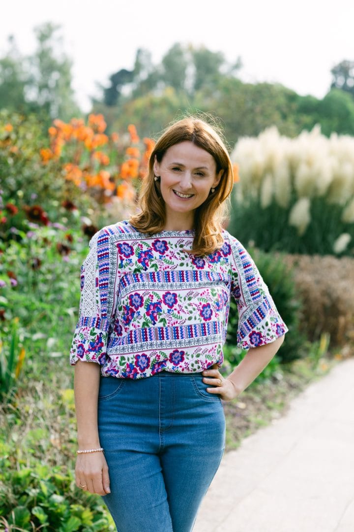 Vibrant embroidered floral top worn by woman in colourful garden setting high-quality UK portrait photography.