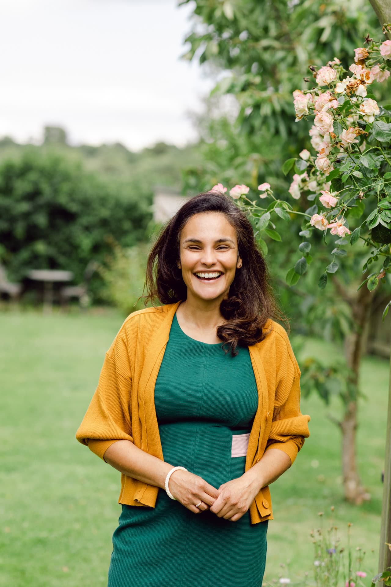 Vibrant portrait of a smiling woman outdoors in a garden, highlighting natural beauty and photography skills.