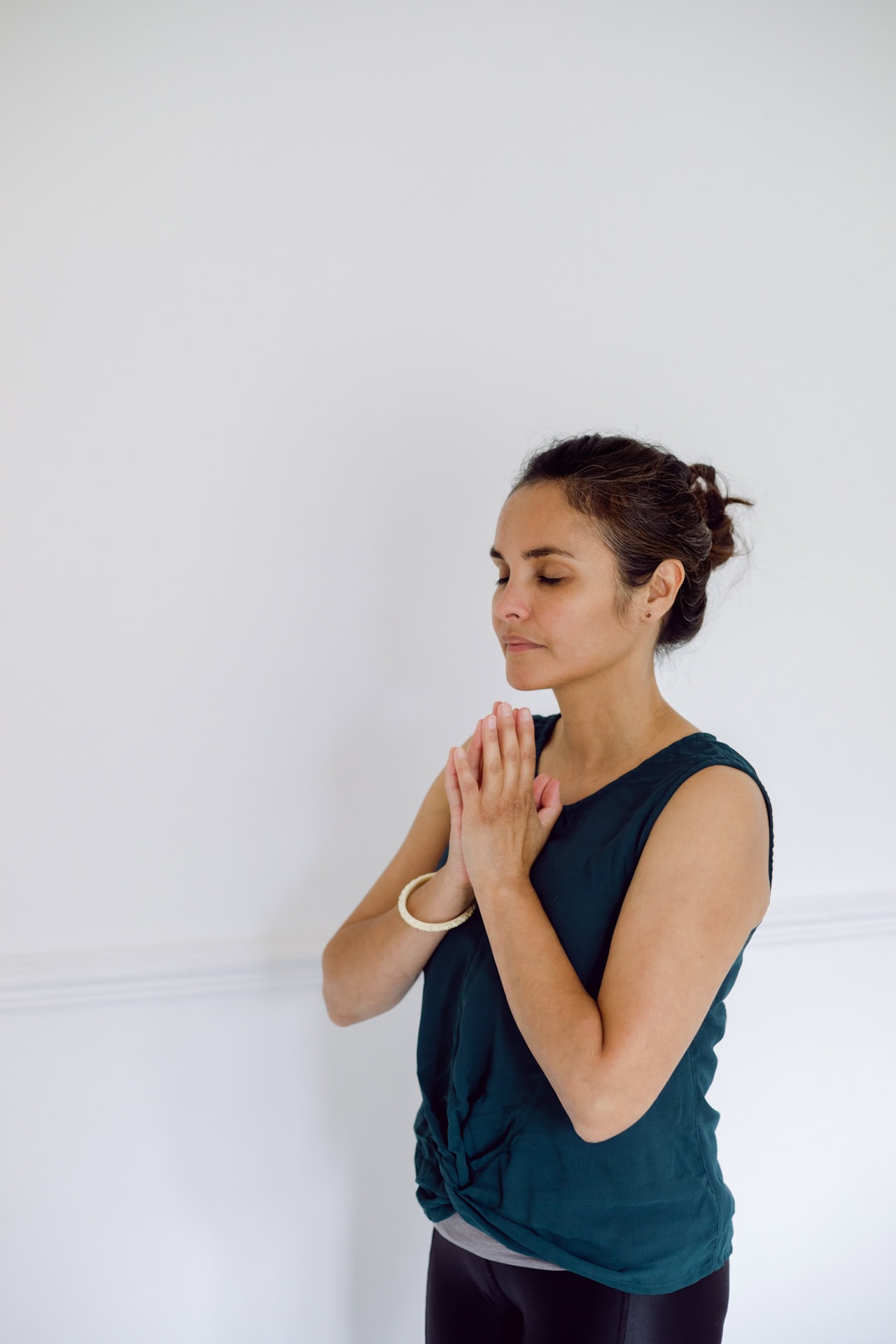 Calm woman practicing yoga and meditation, focusing on mindfulness and relaxation, in a minimalistic setting.